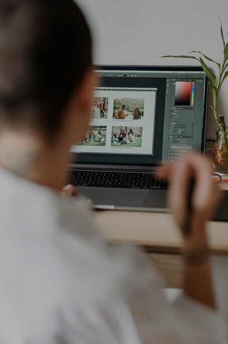 Over the shoulder of a designer creating an engaging digital marketing campaign in Photoshop.