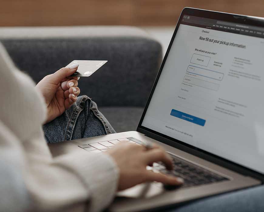 Customer holding a credit card whilst making a purchase on an ecommerce website